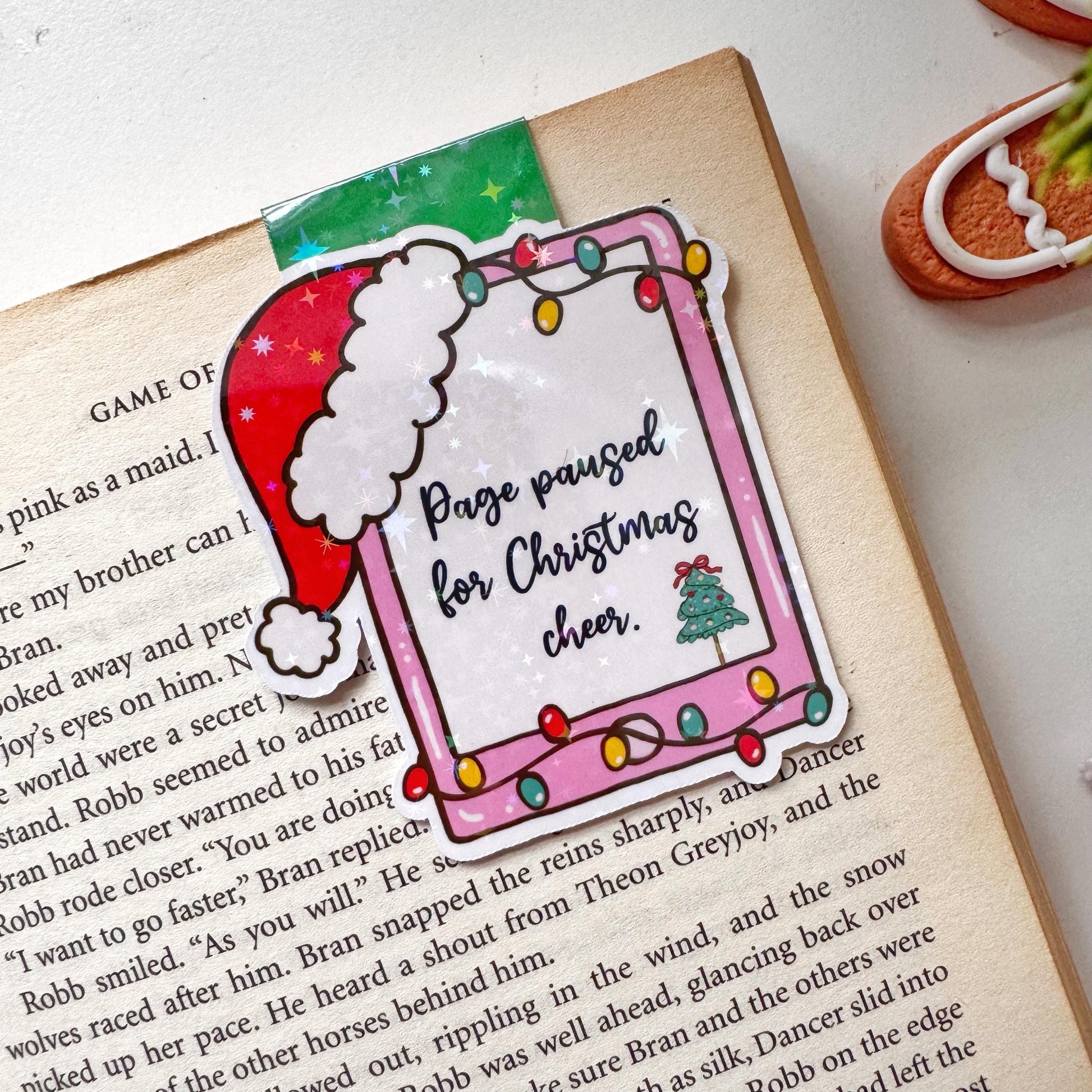 Page paused for Christmas Cheer Santa Cap Magnetic Bookmark: Book Lover Gift